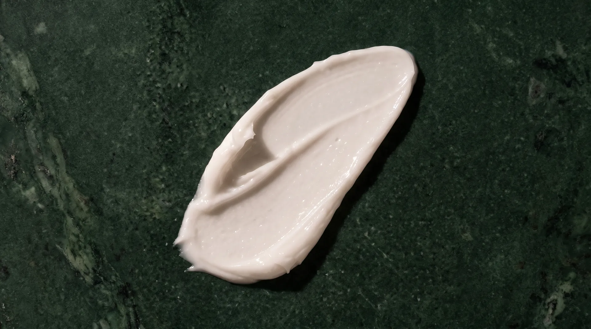 Textura do creme sobre pedra verde